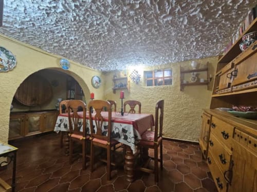 Comedor rústico en la cabaña Las Casitas de Noe con muebles de madera, techo texturizado y decoración tradicional