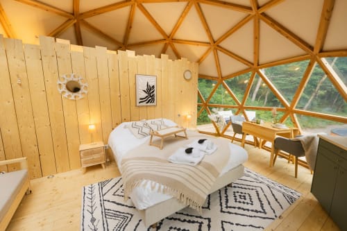 Chambre en dôme géodésique luxueuse aux Cabanes du Nideck avec intérieur en bois, vue sur les montagnes et équipements modernes