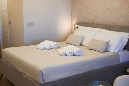 Conchiglia apartment bedroom at Vimini Apulian Experience in Bari with neatly made bed and rolled towels