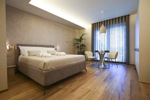 Modern bedroom at Vimini Apulian Experience in Bari with sea view, featuring contemporary bed, pendant lighting, and wooden