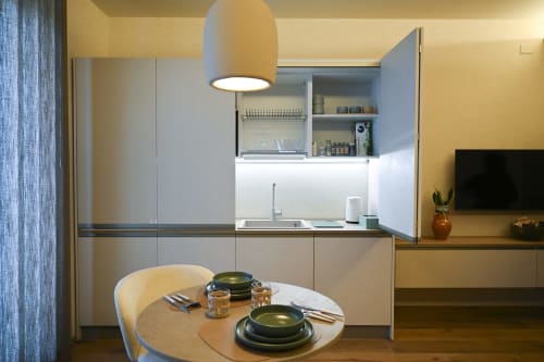 Modern kitchen and dining area in Conchiglia apartment at Vimini Apulian Experience hotel in Bari with round table and sea
