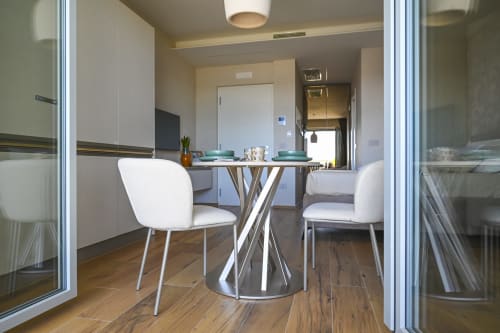 Modern dining area in Conchiglia apartment at Vimini Apulian Experience, Bari, with round table and white chairs