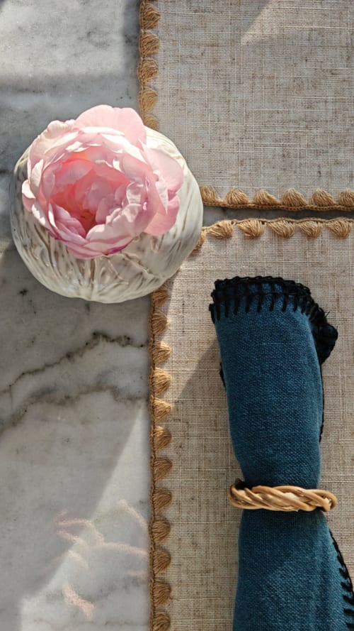 Fleur de pivoine rose à côté d'une serviette bleue avec détail de corde à La Maison 1903, chambres d'hôtes à Trévou-Tréguignec