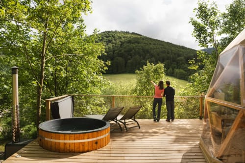 Terrasse en bois avec bain à remous surplombant la forêt et les montagnes aux Cabanes du Nideck, Oberhaslach