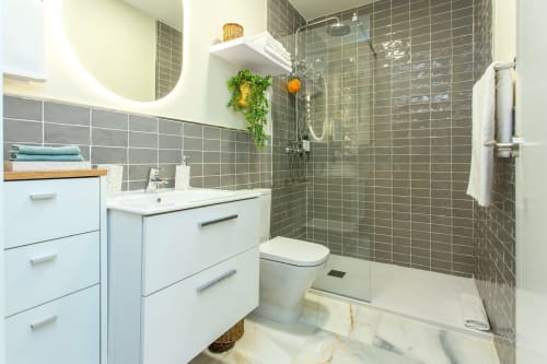 Modern bathroom in Le Petit Palace Catedral apartment, Jerez de la Frontera with walk-in shower, white vanity and gray tiling