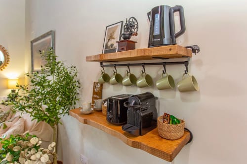 Coffee station with wooden shelves, kettle, mugs, and espresso machine in Le Petit Palace Catedral apartment, Jerez de la