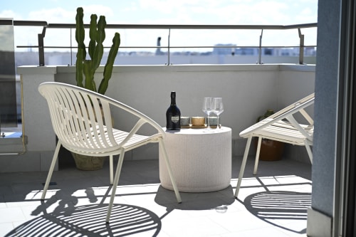 Levante apartment terrace at Vimini Apulian Experience with sea view, white chairs, cactus, and wine setup in Bari