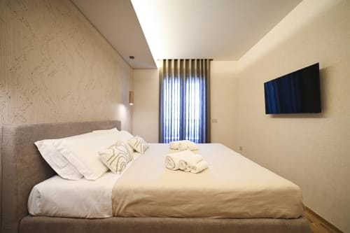 Modern bedroom in Levante apartment at Vimini Apulian Experience hotel in Bari with sea view, flat-screen TV and vertical