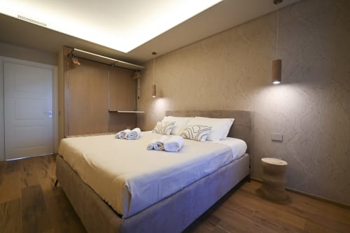 Levante apartment at Vimini Apulian Experience in Bari features a modern bedroom with sea view, wooden floors, pendant