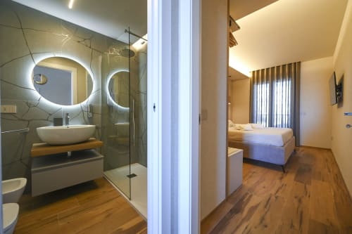 Modern en-suite bathroom with illuminated oval mirrors and shower, Levante room at Vimini Apulian Experience in Bari