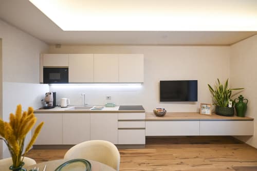 Modern kitchen in Levante apartment at Vimini Apulian Experience, Bari, with white cabinetry, wooden counters, and mounted