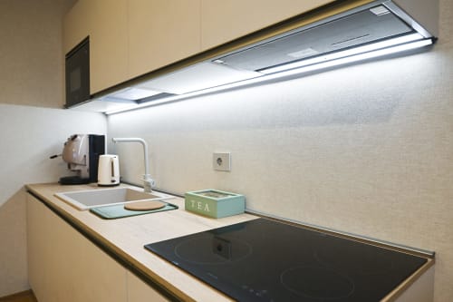 Modern kitchenette in Levante apartment at Vimini Apulian Experience, Bari, with induction cooktop and ambient lighting