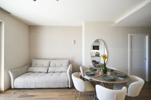 Levante apartment at Vimini Apulian Experience in Bari featuring cream sofa, dining table with place settings, and round