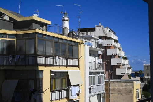 Coastal apartment buildings with lighthouse in Bari, Italy. Vimini Apulian Experience property.