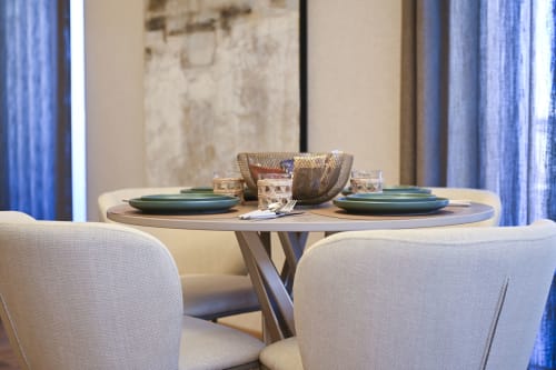 Elegant dining setup in Ginestra apartment at Vimini Apulian Experience with round table, green plates, and cream chairs