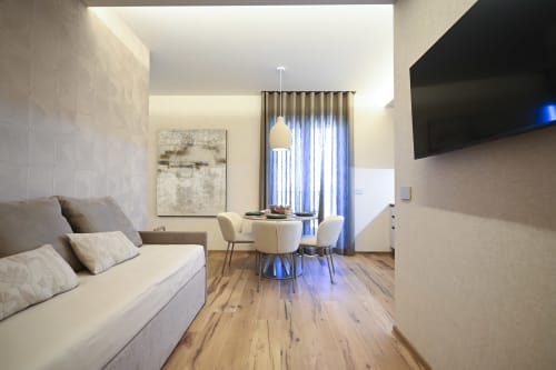 Modern Ginestra apartment at Vimini Apulian Experience in Bari with sofa, dining area, and garden view
