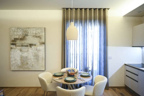 Ginestra apartment dining area at Vimini Apulian Experience, Bari, with round table, cream chairs, pendant light, and garden