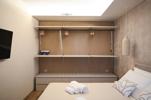Modern hotel bedroom at Vimini Apulian Experience in Bari with wall-mounted shelving, pendant lights, and garden views