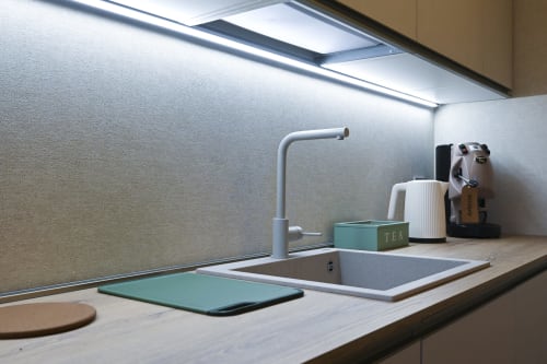 Modern kitchenette in Ginestra apartment at Vimini Apulian Experience, Bari, with white sink, faucet, and tea accessory on