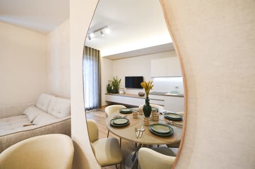 Sala da pranzo dell'Apulian Experience con tavolo apparecchiato, cucina e zona lounge a Bari
