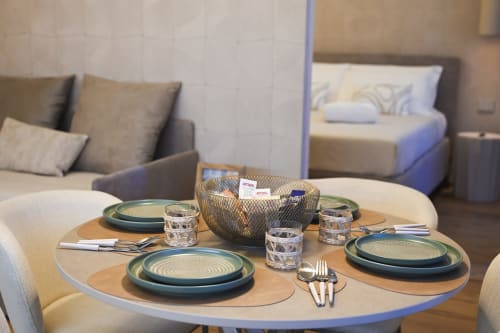 Elegante tavolo rotondo con piatti turchesi e sedute accoglienti presso Vimini Apulian Experience a Bari