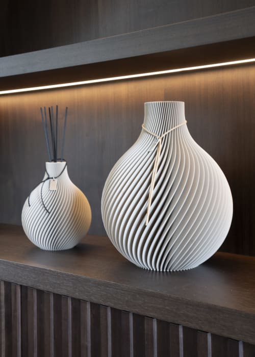 Two modern white ribbed decorative vases with dark sticks displayed on wooden shelf at The Coach House villa, Oxford