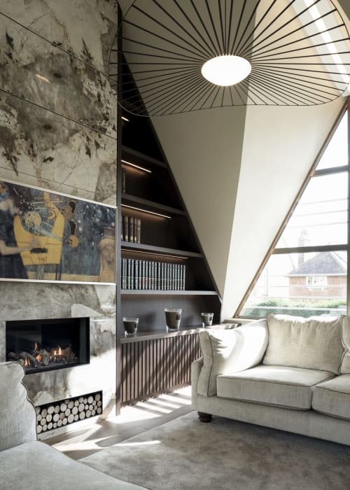 Modern villa lounge with fireplace, skylight ceiling, contemporary furnishings and garden views at The Coach House