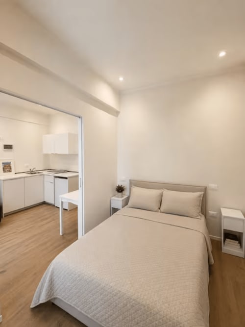 Monolocale moderno a La Superba Stay Genova con letto, angolo cottura e arredamento minimalista beige