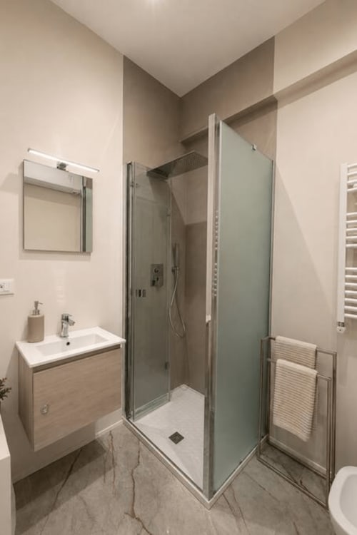 Bagno moderno nelle Cittadella Suites di La Superba Stay Genova con doccia in vetro, lavabo e scaldasalviette