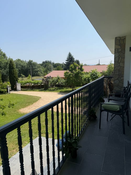 Vista del balcón en Bikarte Os Condes en Sober, España con paisaje rural y jardines verdes