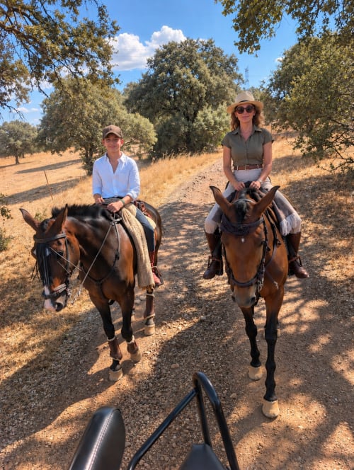 Dos huéspedes cabalgando en un sendero rural cerca de El descanso del peregrino en Guadalupe, Cáceres, España.