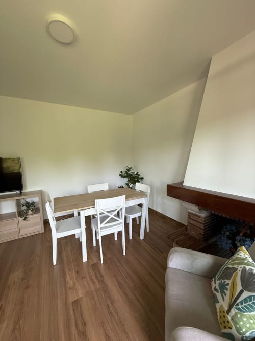 Habitación del hotel Bikarte en Sober con comedor, sillas blancas, chimenea y acogedora zona de estar