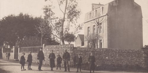 Manoir ancien en pierre avec clients rassemblés à l'extérieur, Gîte La Maison 1903 à Trévou-Tréguignec