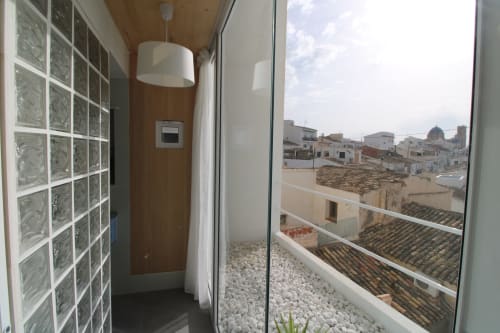 Balcón moderno del Hostal Fornet Altea con vistas al mar sobre edificios de tejado de barro y patio de grava blanca
