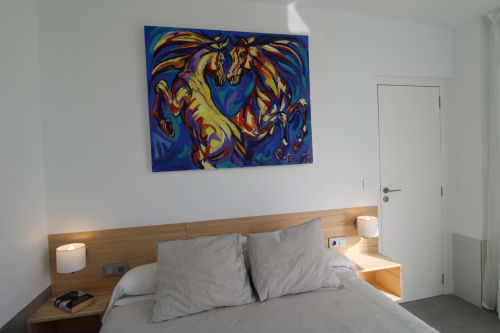 Dormitorio moderno del Hostal Fornet Altea con cabecero de madera, arte abstracto colorido y decoración minimalista