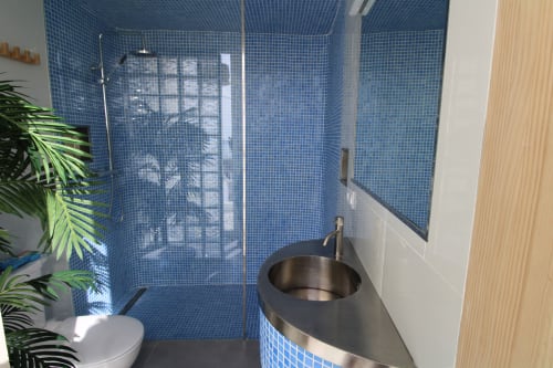 Baño moderno del Hostal Fornet Altea con azulejos de mosaico azul, ducha con cristal y lavabo redondo tipo vasija