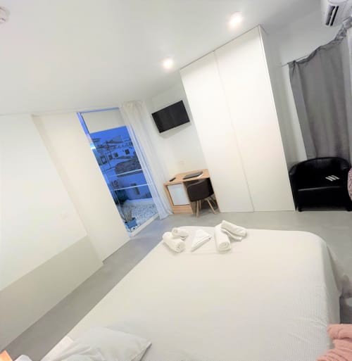 Suite Deluxe moderna con vistas al mar en Hostal Fornet Altea, cama blanca, TV pantalla plana, escritorio y balcón con vistas