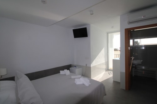 Suite junior luminosa con vistas al mar en Hostal Fornet Altea, con cama, TV, acceso a balcón y amenidades modernas