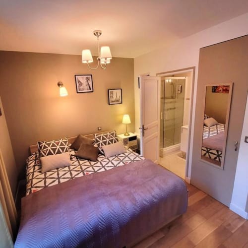 Chambre Joana cosy de l'Hôtel OH Sèvres, au sud de la France, avec lit queen-size, salle de bains attenante et éclairage ambiant chaleureux