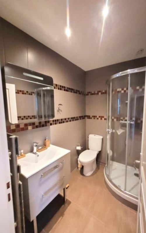 Modern bathroom in Deluxe Apartment at Hôtel OH Sèvres Autormente, Sèvres with white vanity, toilet, corner shower and