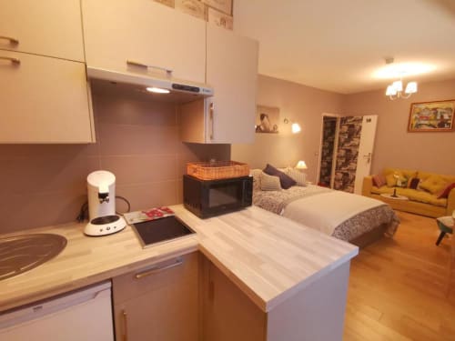 Deluxe apartment at Hôtel OH Sèvres Autrement with kitchen, bed, and living area