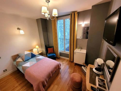 Chambre Gaya à l'Hôtel OH Sèvres Autterson avec lit, salle de bains attenante, portes-fenêtres avec rideaux dorés et design moderne