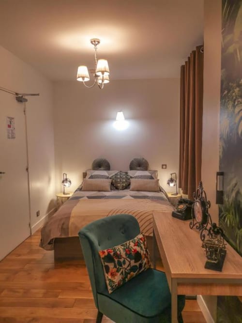 Chambre élégante de luxe à l'Hôtel OH Sèvres Autrement, éclairage chaleureux, parquets et décoration contemporaine