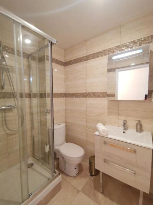 Salle de bains moderne avec douche, toilettes et lavabo dans l'Appartement Supérieur à l'Hôtel OH Sèvres Autrement, Sèvres