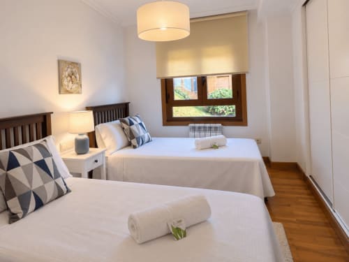 Dormitorio doble en apartamento A Dourada en Holibai, Baiona con vistas al mar, muebles modernos e iluminación natural