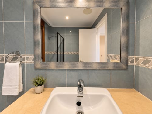 Lavabo moderno con espejo enmarcado en apartamento A Dourada de Holibai, Baiona