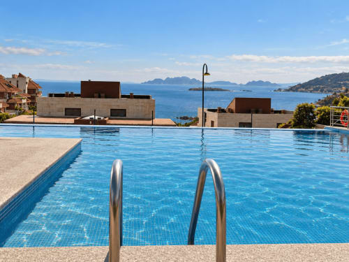 Piscina infinita con vistas a las aguas costeras y islas de Baiona, apartamento Holibai con vistas al mar