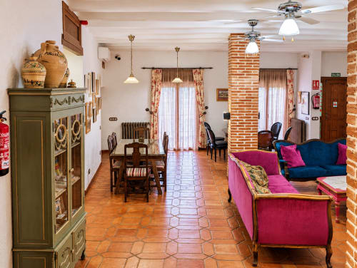 Amplia sala común en El descanso del peregrino villa boutique en Guadalupe con pisos de terracota, columnas de ladrillo y colorido