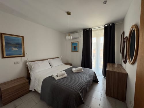 Modern bedroom at THE V Collection in Sormano with queen bed, mountain view, black curtains, and wooden furniture