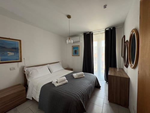 Modern bedroom at THE V Collection apartment in Sormano with queen bed, black accents, mountain views, and contemporary